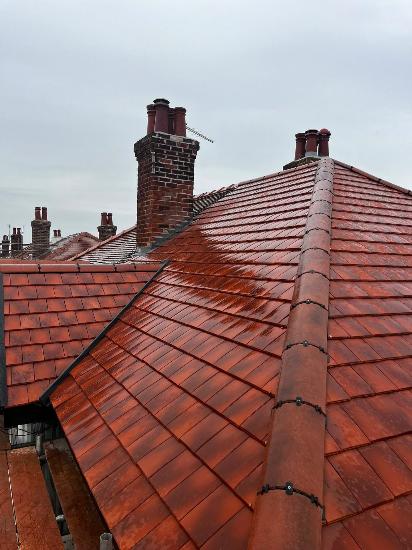 New red clay tile roof around a red-brick Victorian chimney stack with lead flashings by RTC Roofing