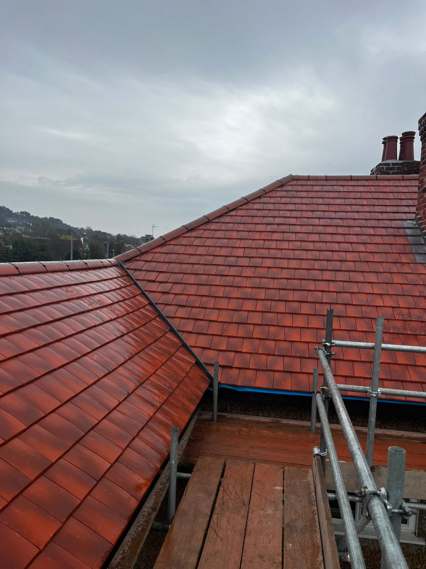 Close-up of a red clay hip tile run with dry-ridge clips on a Wirral re-roof by RTC Roofing