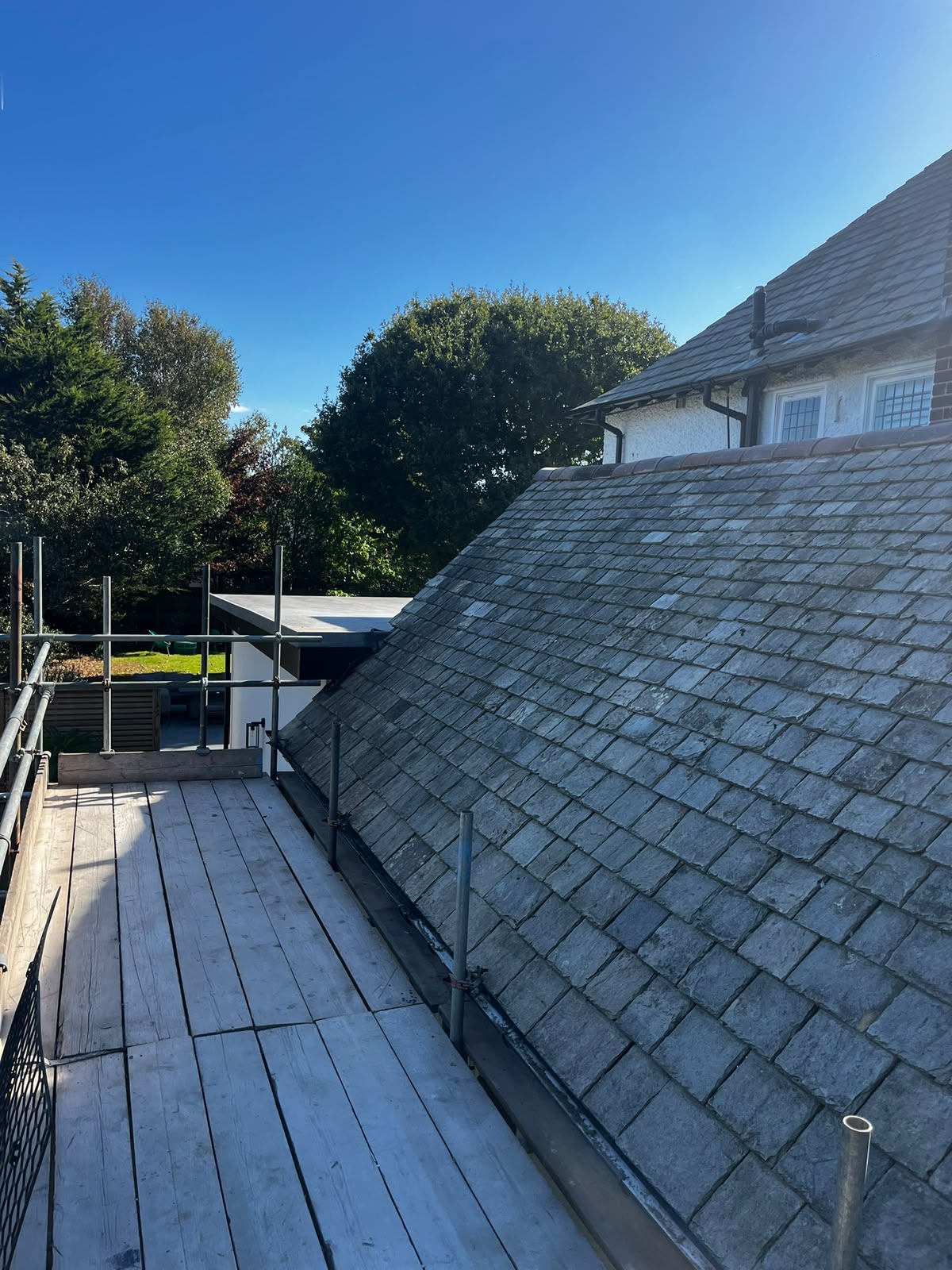 Original grey slate roof and chimney in sunlight prior to re-slating works, RTC Roofing Wirral