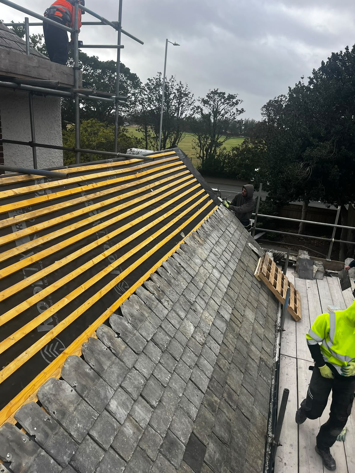 Mid re-roof strip with new treated battens over blue breathable membrane above existing slate courses, RTC Roofing