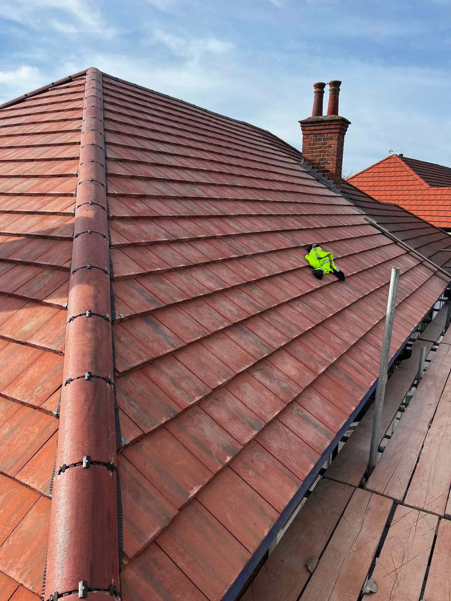 Completed red clay tile hipped roof scaffolded at eaves level, by RTC Roofing on the Wirral