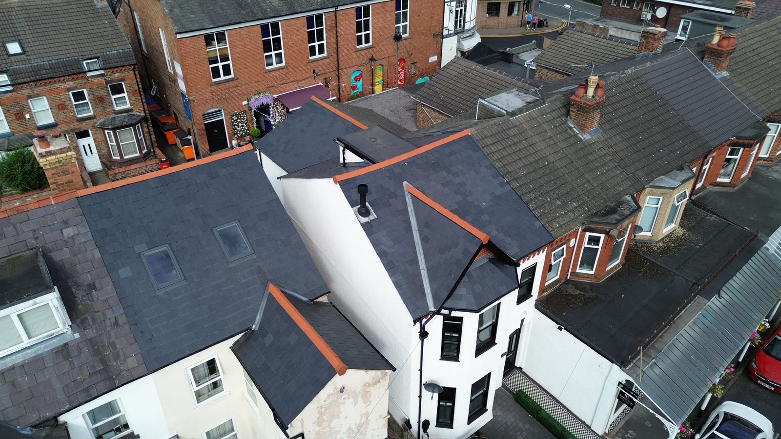 Completed natural slate re-roof on a Merseyside terrace, viewed along the ridge line — RTC Roofing