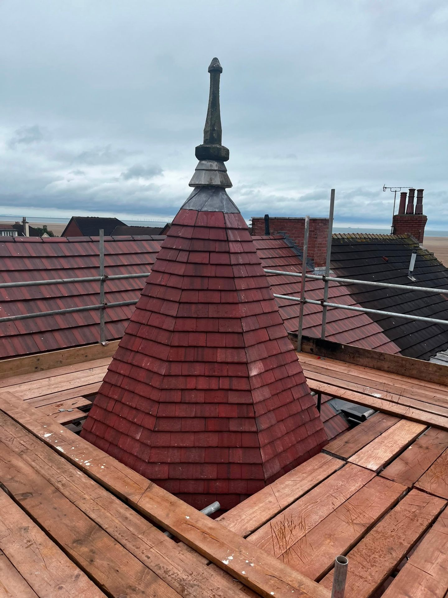 Heritage red clay tile conical turret with lead-clad spire and finial, restored by RTC Roofing on the Wirral coast