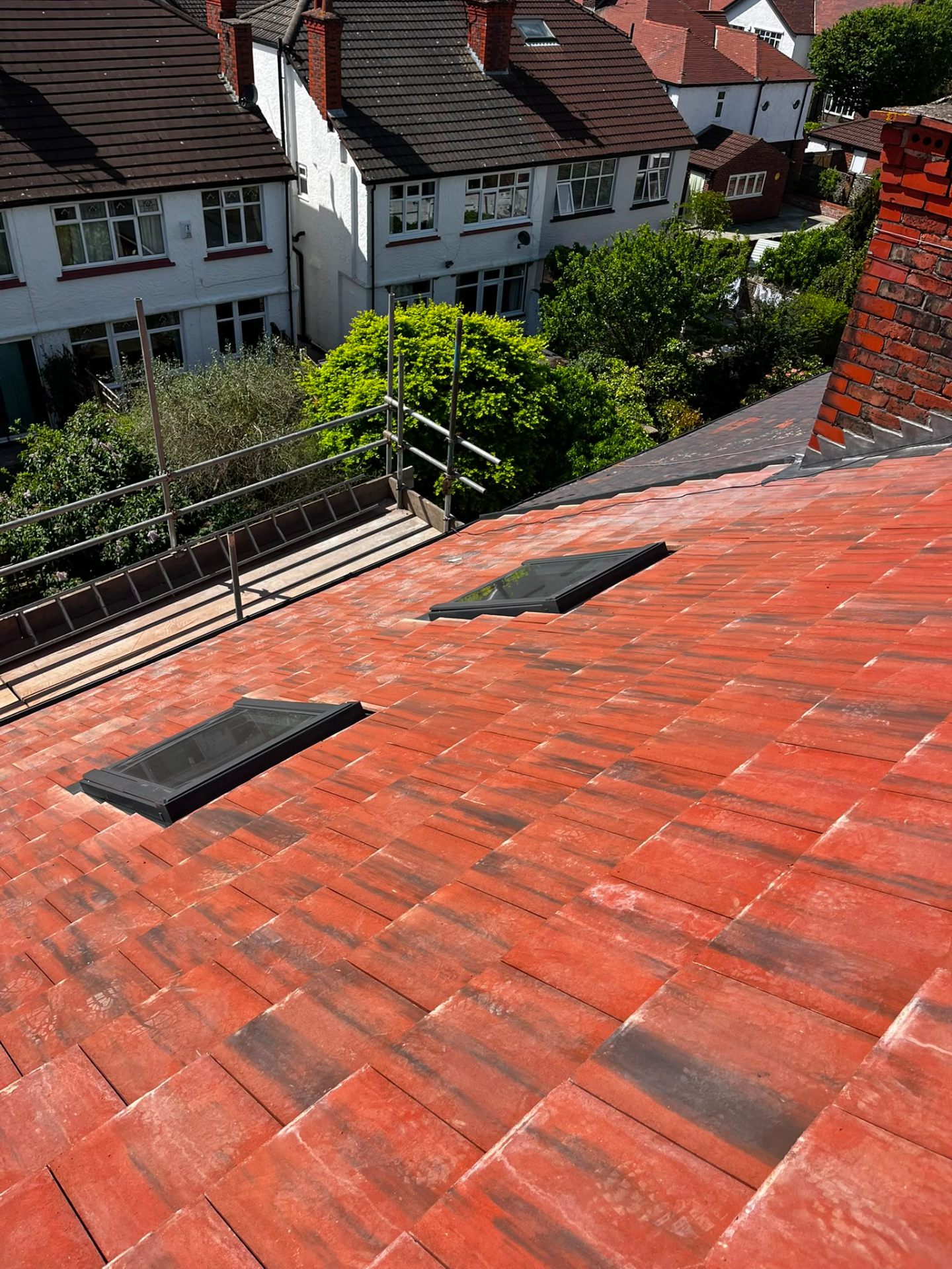Freshly completed red clay tile re-roof on a Wirral home with clean eaves and gutter line by RTC Roofing