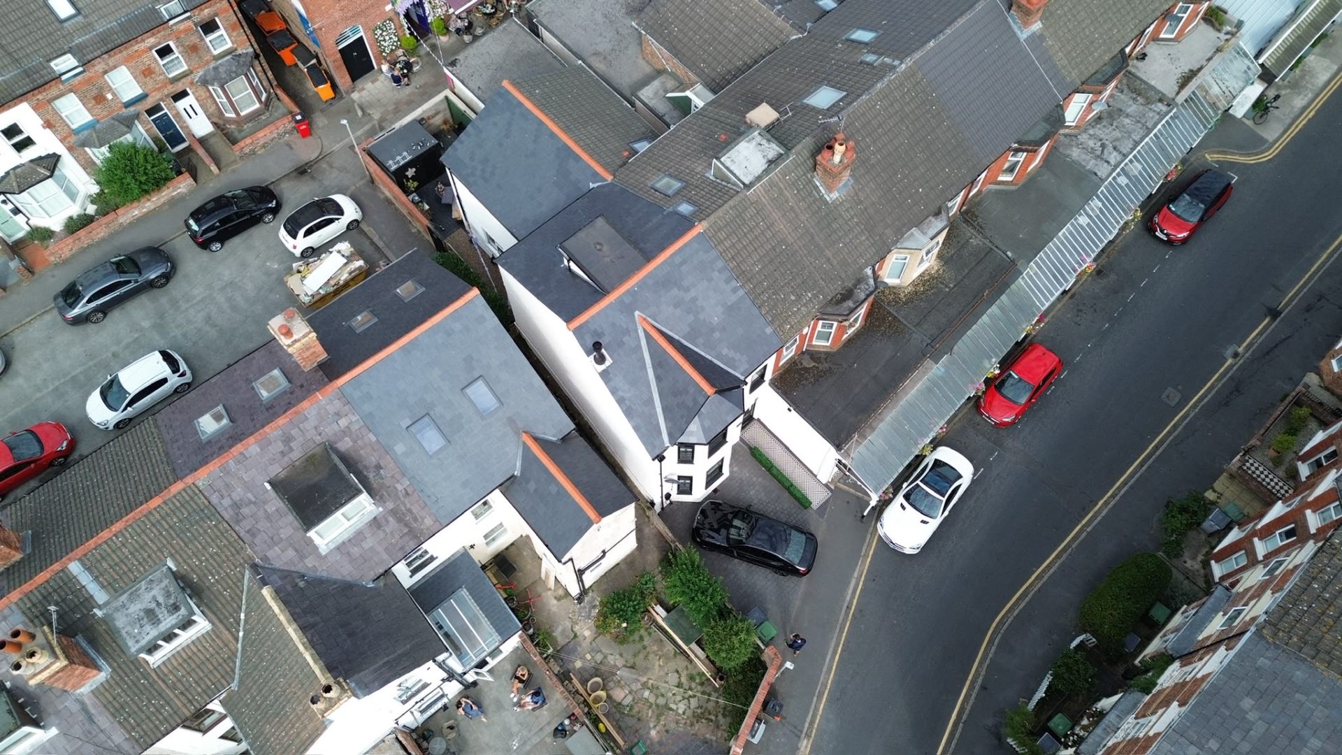 Aerial view of new natural slate roofs with clay hip caps across a Merseyside terrace, RTC Roofing