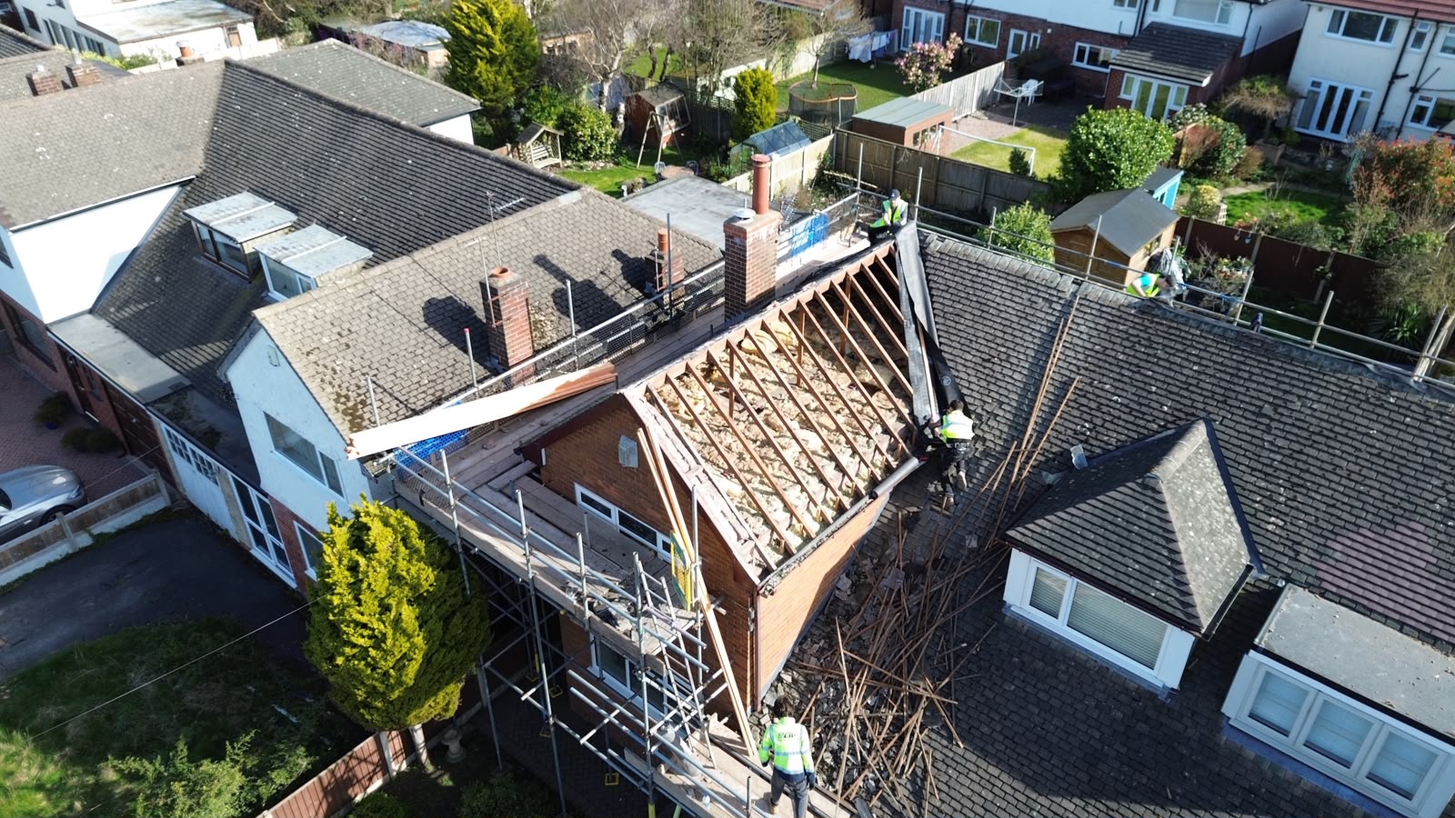 Aerial view of an in-progress re-roof — old roof stripped back to rafters with scaffold in place, RTC Roofing